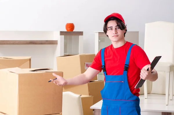 Jovem empreiteiro masculino com caixas trabalhando dentro de casa — Fotografia de Stock