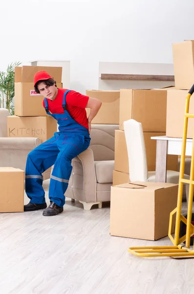 Jovem empreiteiro masculino com caixas trabalhando dentro de casa — Fotografia de Stock