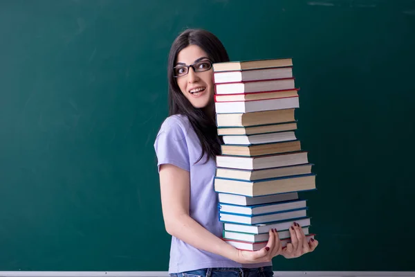 Jovem estudante professora na frente do quadro verde — Fotografia de Stock