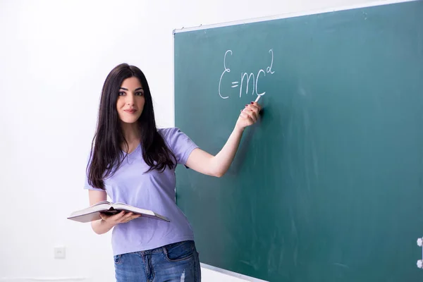 Joven profesora estudiante delante del tablero verde — Foto de Stock