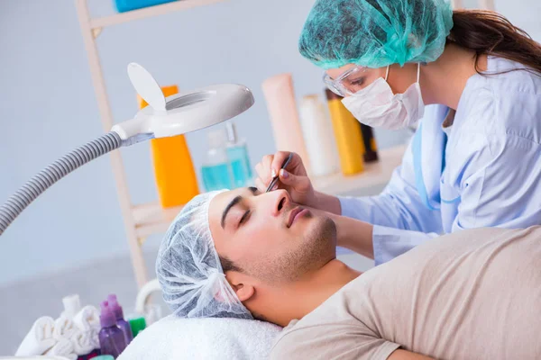 Jovem homem bonito visitando médico cosmetologista feminino — Fotografia de Stock