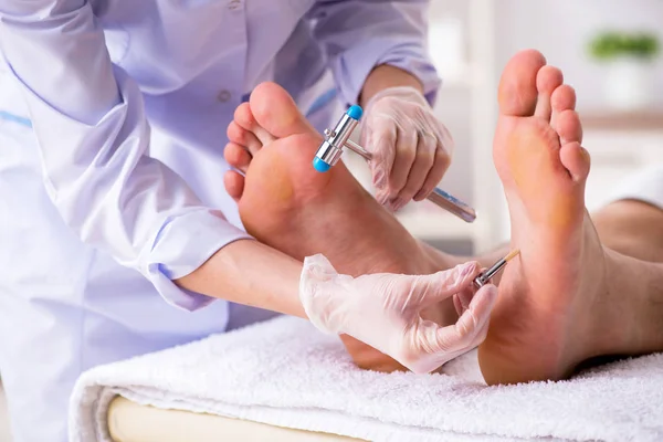 Podólogo tratando los pies durante el procedimiento — Foto de Stock