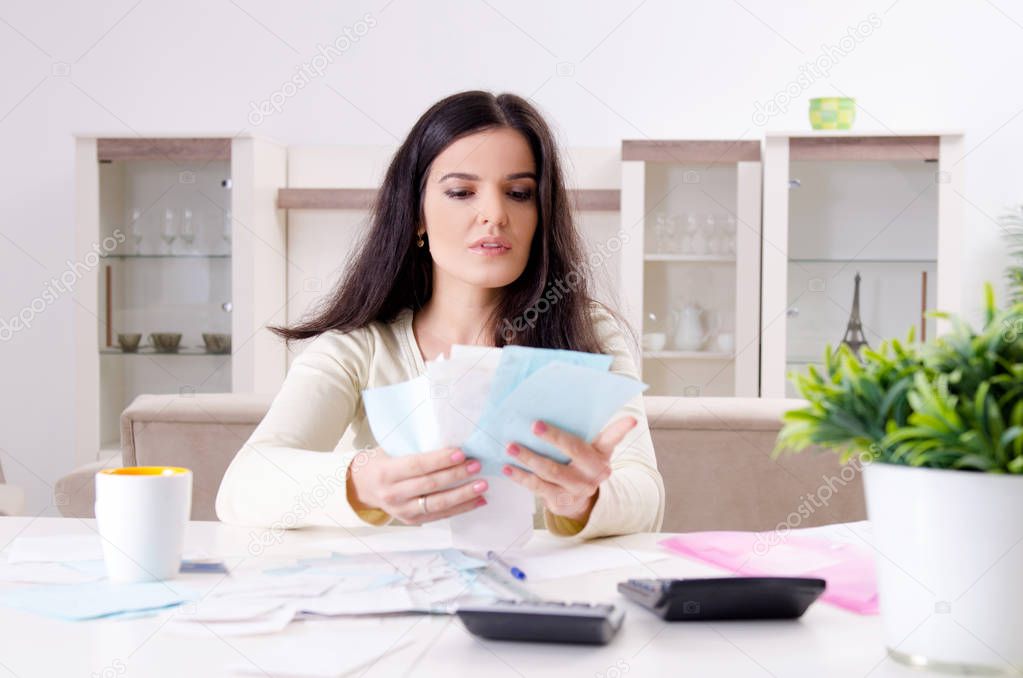 Young woman with receipts in budget planning concept 