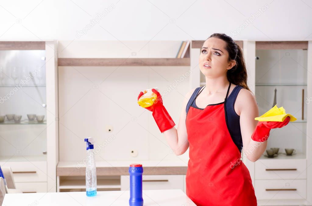 Young beautiful woman cleaning apartment 