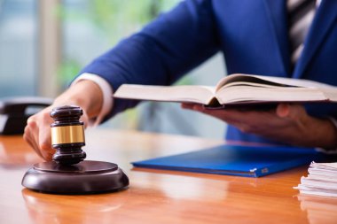 Genç erkek yargıç mahkeme salonunda oturuyor. 