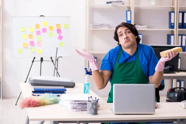 Male handsome professional cleaner working in the office