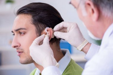 İşitme sorunu olan erkek hasta doktor otorhinolaryng 'i ziyaret ediyor.