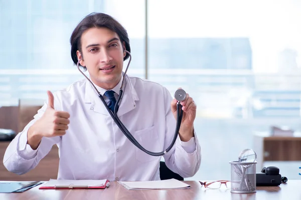 Jovem médico bonito que trabalha na clínica — Fotografia de Stock