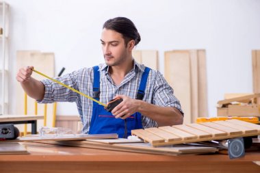 Genç erkek marangoz içeride çalışıyor. 