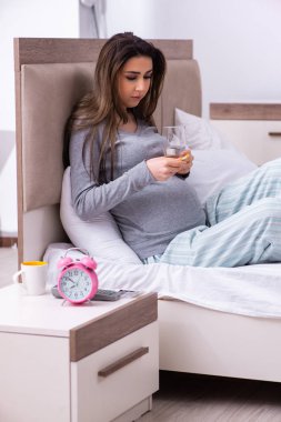 Genç hamile kadın yatak odasında. 