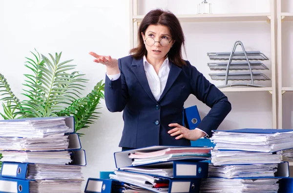 Middle-aged businesswoman unhappy with excessive work — Stock Photo, Image