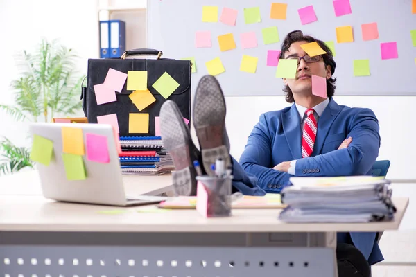 Jonge mannelijke knappe werknemer in tegenstrijdige prioriteiten concept — Stockfoto