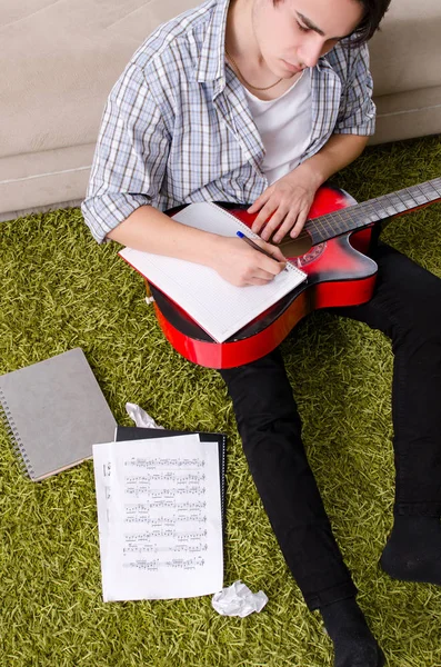 Jovem com guitarra em casa — Fotografia de Stock