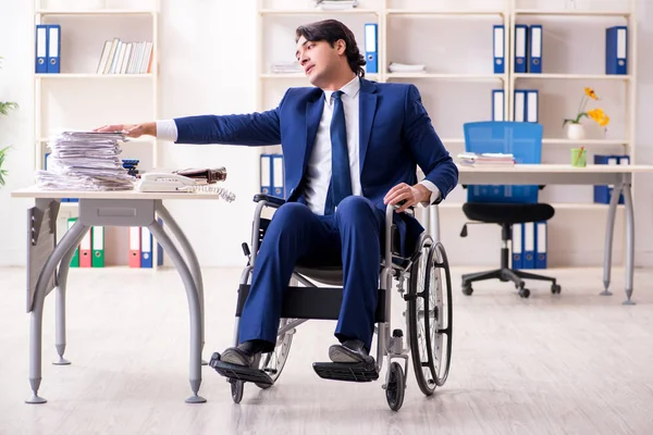 Joven empleado masculino en silla de ruedas que trabaja en la oficina —  Fotos de Stock