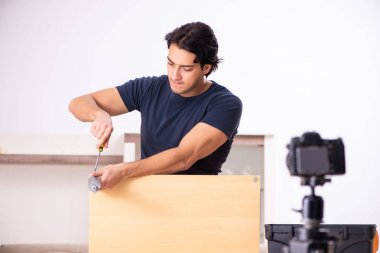 Genç erkek tamirci blogu için video kaydediyor. 