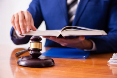 Genç erkek yargıç mahkeme salonunda oturuyor. 