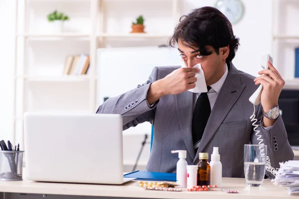 Man met griep die op kantoor werkt — Stockfoto