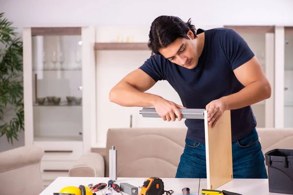 Young man repairing furniture at home