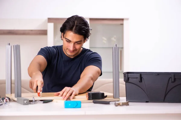 Young man repairing furniture at home