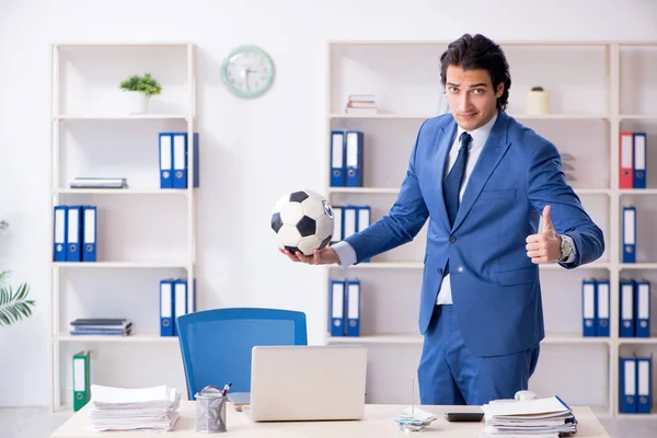 在办公室里拿着足球的年轻英俊的商人 — 图库照片