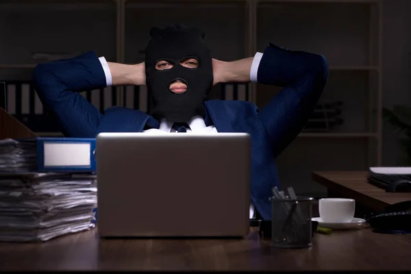Работник-мужчина крадет информацию в офисе ночью — стоковое фото