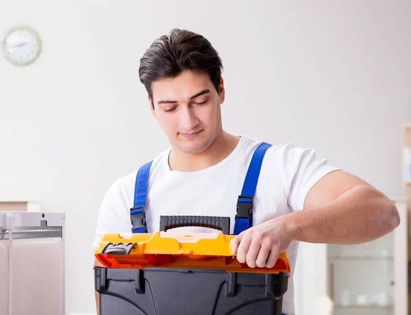 Repairman contractor repairing fridge in DIY concept