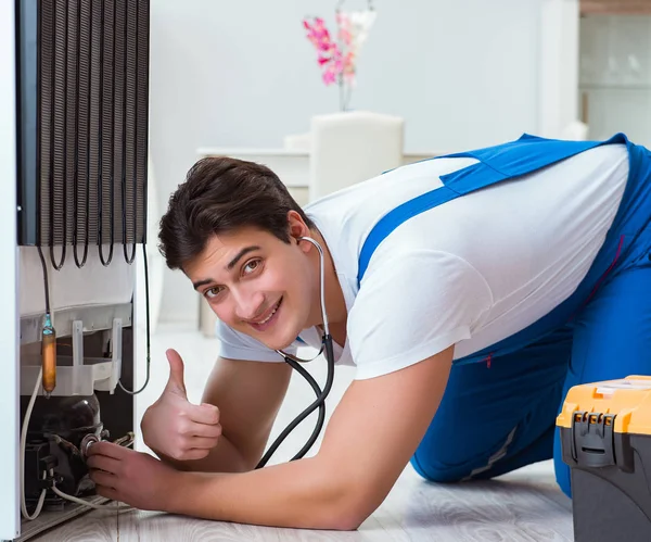 Repairman contractor repairing fridge in DIY concept