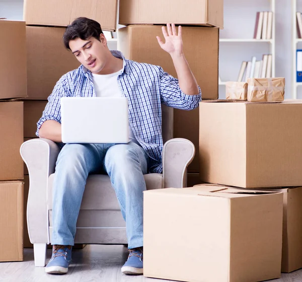 Young man moving in to new house with boxes — Stock Photo, Image