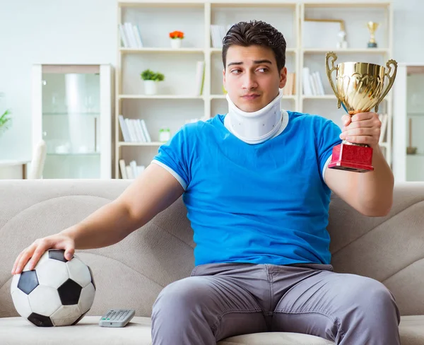 Uomo con infortunio al collo guardando calcio a casa — Foto Stock