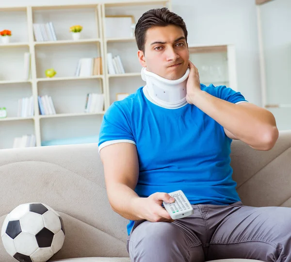 Hombre con lesión en el cuello viendo fútbol fútbol en casa —  Fotos de Stock