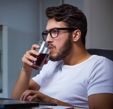 Genç adam fazla mesai yapmak için geç saatlere kadar ofiste kalıyor.