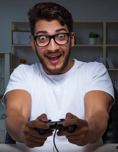 Jovem jogando jogos longas horas atrasado no escritório — Fotografia de Stock