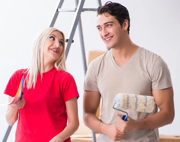 Família jovem fazendo trabalho de pintura durante a renovação da casa — Fotografia de Stock