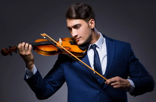 Jovem tocando violino no quarto escuro — Fotografia de Stock