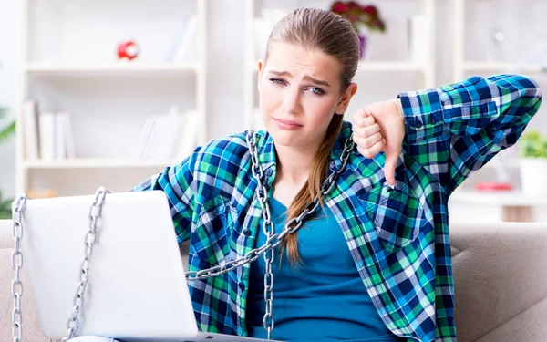 Chained female student with laptop sitting on the sofa — Stock Photo, Image