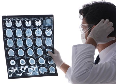 Röntgen görüntülerine bakan genç doktor beyazda izole edilmiş.