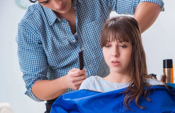 Man male hairdresser doing haircut for woman