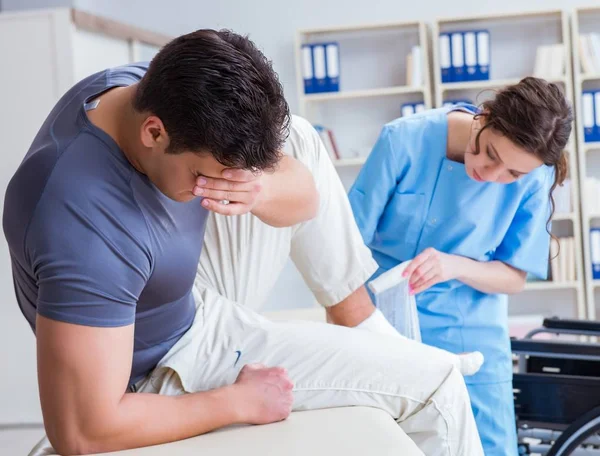 Médico y paciente durante el control de la lesión en el hospital — Foto de Stock