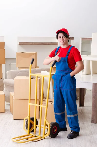 Jovem empreiteiro masculino com caixas trabalhando dentro de casa — Fotografia de Stock