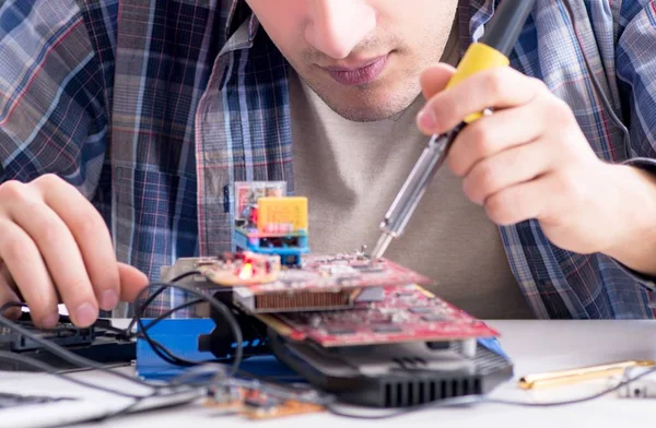 Professional repairman repairing computer in workshop