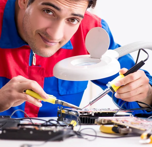 Professional repairman repairing computer in workshop