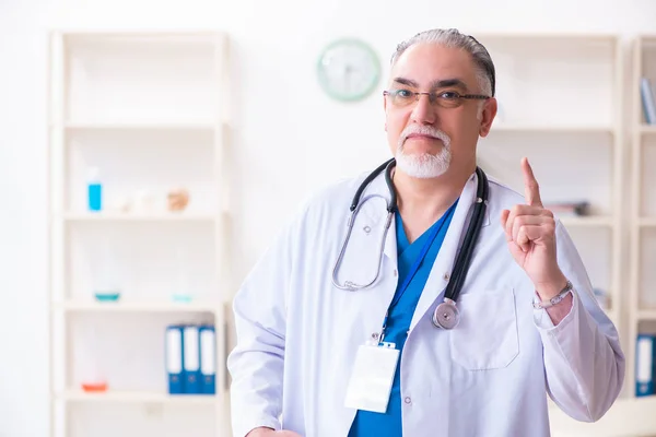 Velho médico do sexo masculino trabalhando na clínica — Fotografia de Stock