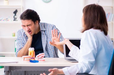 Genç adam kadın doktor stomatoloğu ziyaret ediyor.