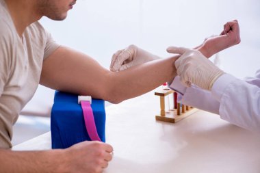 Kan testi örnekleme işlemi sırasında genç yakışıklı adam. 