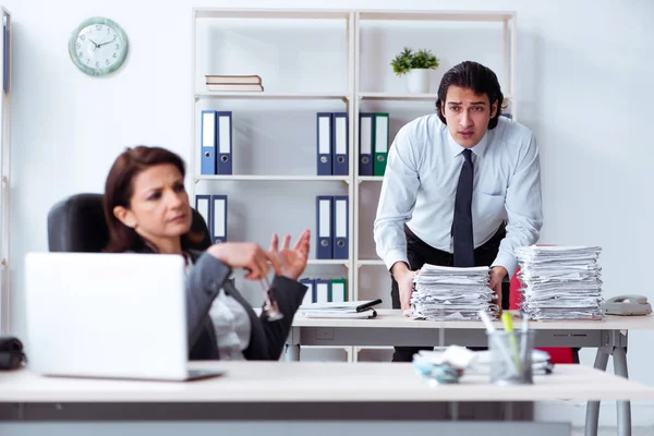 Old female boss and young male employee in the office