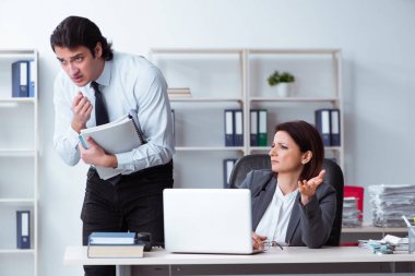 Yaşlı kadın patron ve genç erkek çalışan ofiste.  