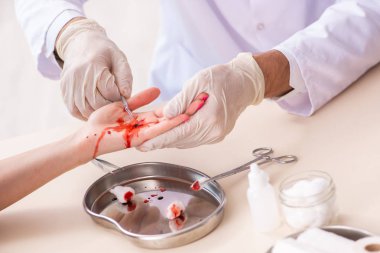 Yaralı kadın erkek doktoru ziyaret ediyor. 