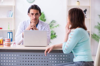 Orta yaşlı bir kadın, erkek doktor stomatoloğu ziyaret ediyor.