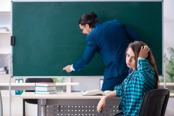 Jonge knappe leraar en vrouwelijke student in de klas — Stockfoto