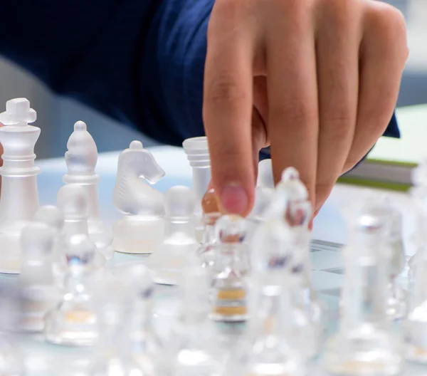 Young businessman playing glass chess in office — Stock Photo, Image